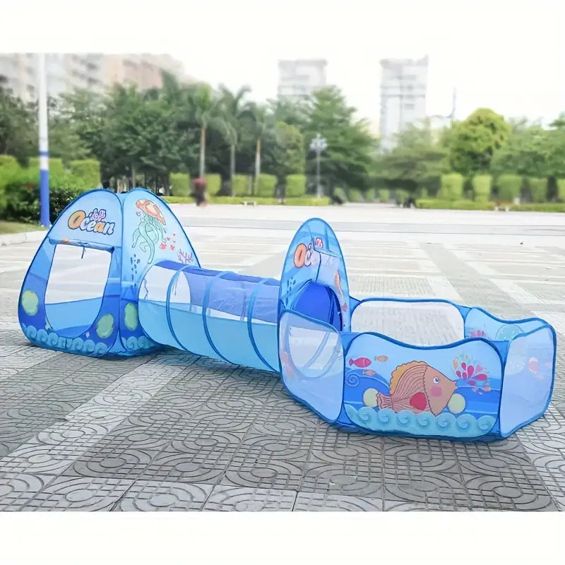 Children's play set with blue tunnel and ocean-themed design on a pavement.